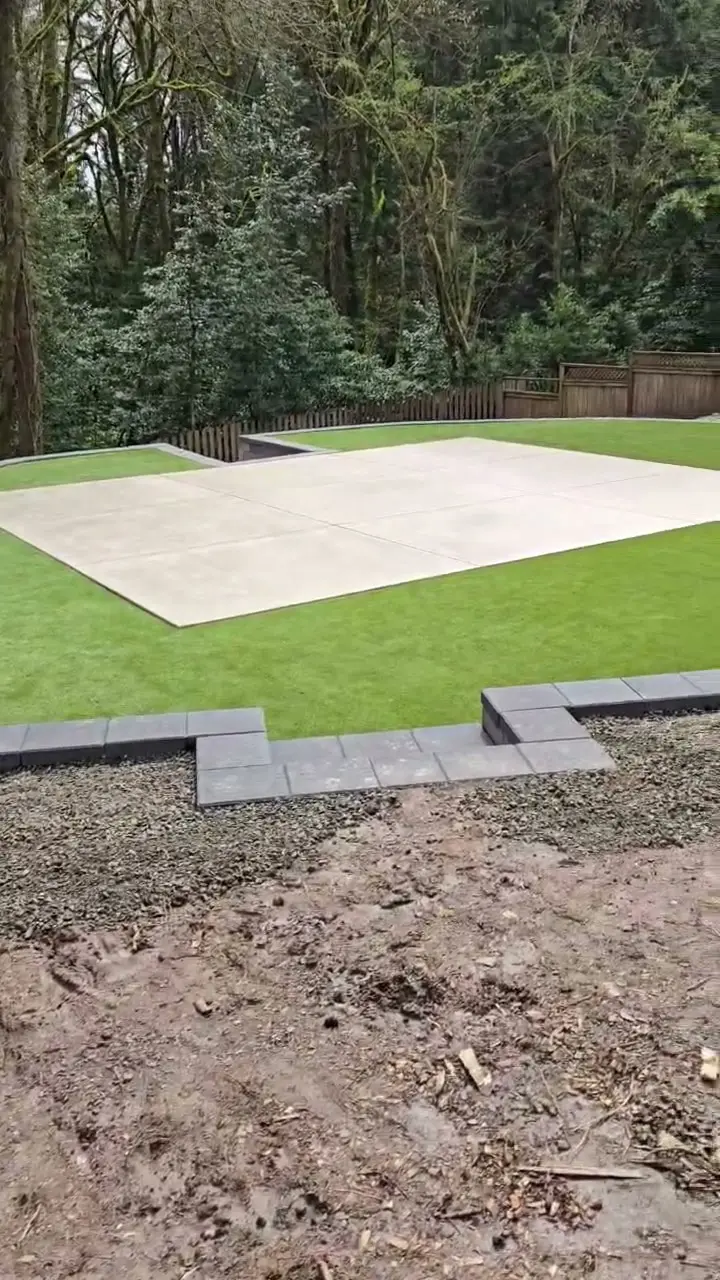 Portland backyard lawn surrounding a large concrete patio